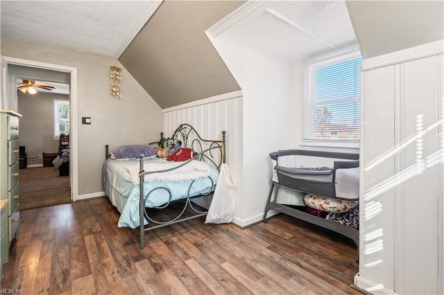 bedroom featuring lofted ceiling, dark hardwood / wood-style flooring, and a textured ceiling