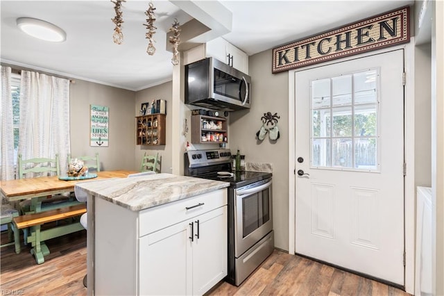 kitchen featuring white cabinetry, kitchen peninsula, stainless steel appliances, light wood-type flooring, and light stone countertops