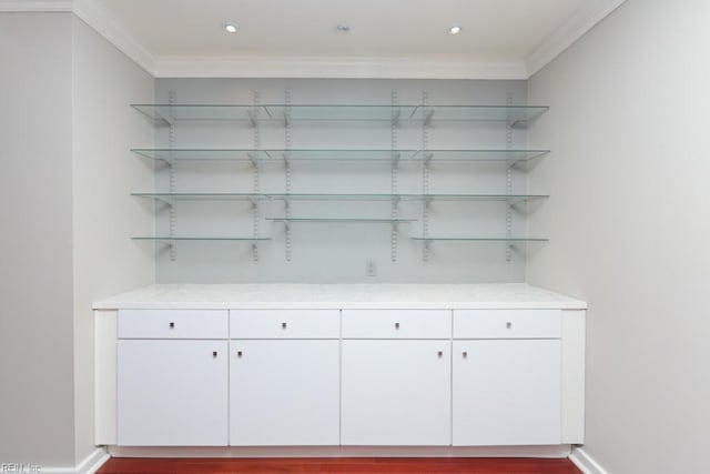 bar with crown molding and white cabinets