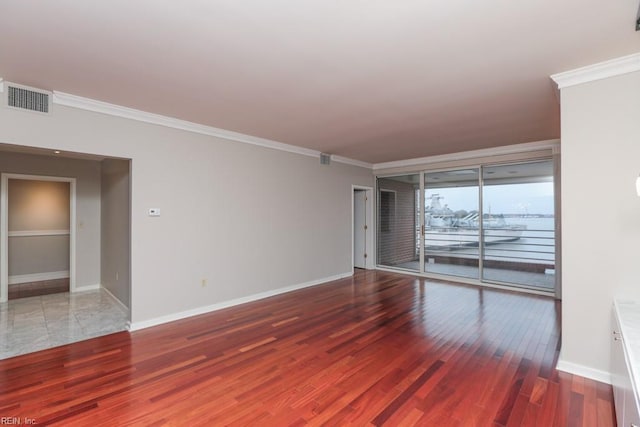 empty room featuring crown molding and wood-type flooring