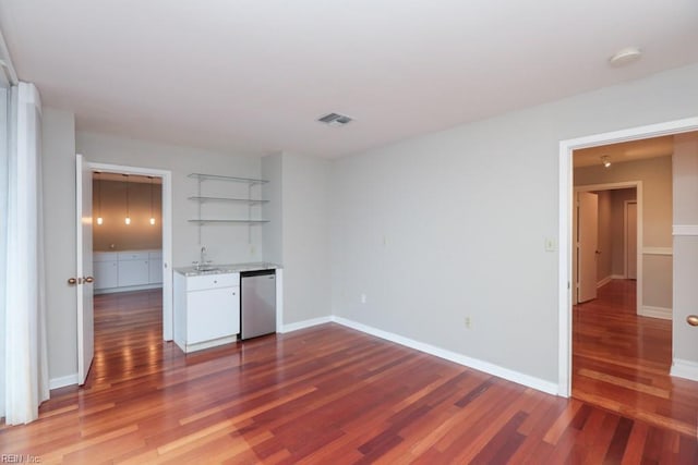 empty room featuring dark wood-type flooring and indoor wet bar