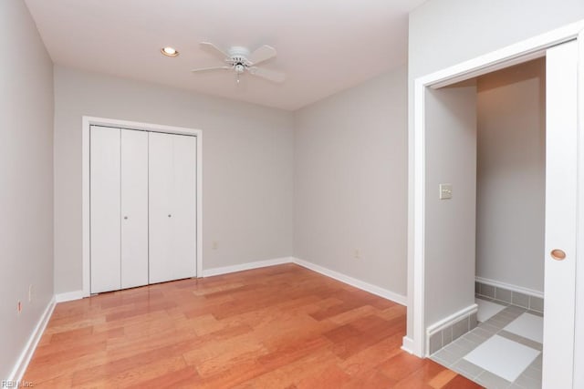 unfurnished bedroom with light hardwood / wood-style flooring, a closet, and ceiling fan