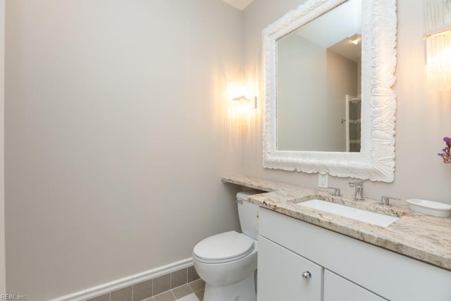 bathroom featuring vanity, tile patterned floors, and toilet