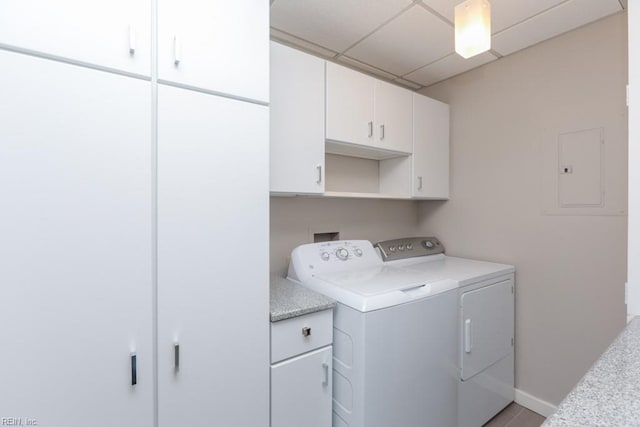 clothes washing area featuring cabinets, washing machine and dryer, and electric panel