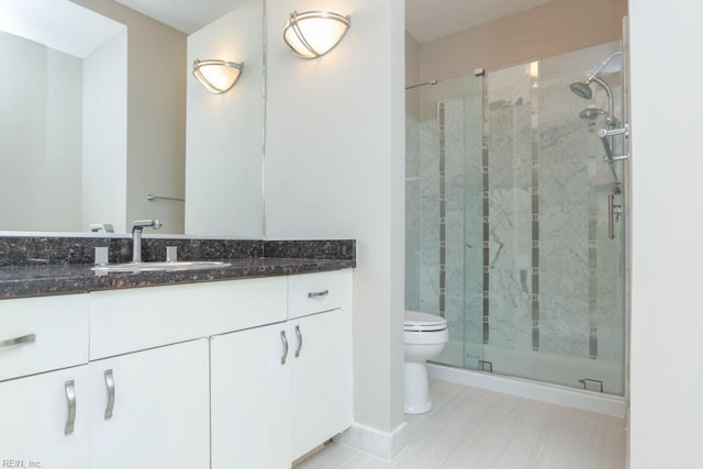 bathroom with vanity, toilet, and a shower with shower door