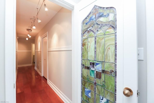 hallway with dark hardwood / wood-style flooring and rail lighting