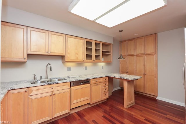 kitchen with pendant lighting, light stone countertops, sink, and paneled dishwasher