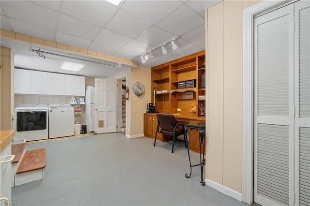 home office featuring built in desk, independent washer and dryer, and a drop ceiling