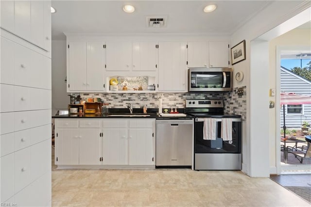 kitchen featuring white cabinetry, stainless steel appliances, tasteful backsplash, sink, and ornamental molding