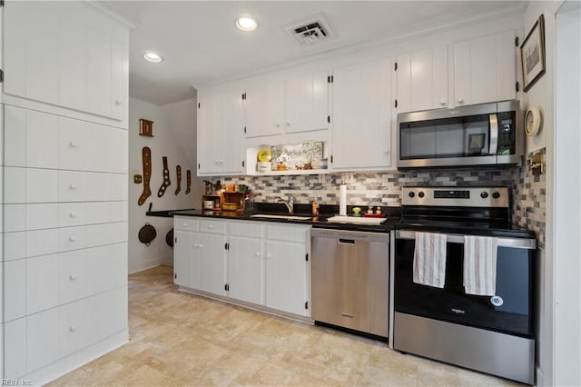 kitchen with white cabinets, appliances with stainless steel finishes, sink, backsplash, and ornamental molding