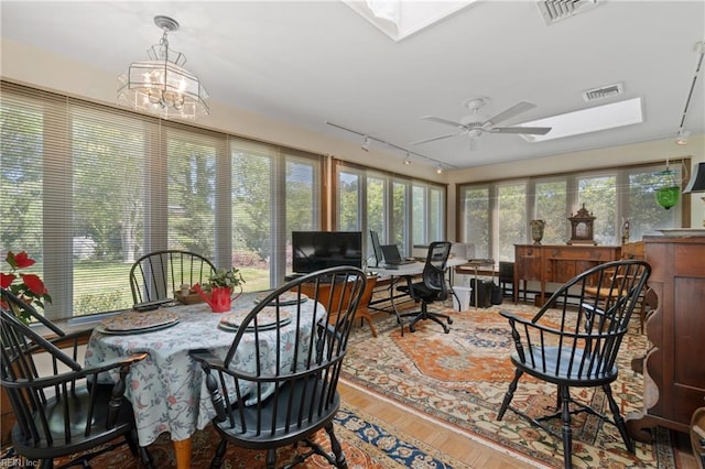 sunroom / solarium featuring ceiling fan and a skylight