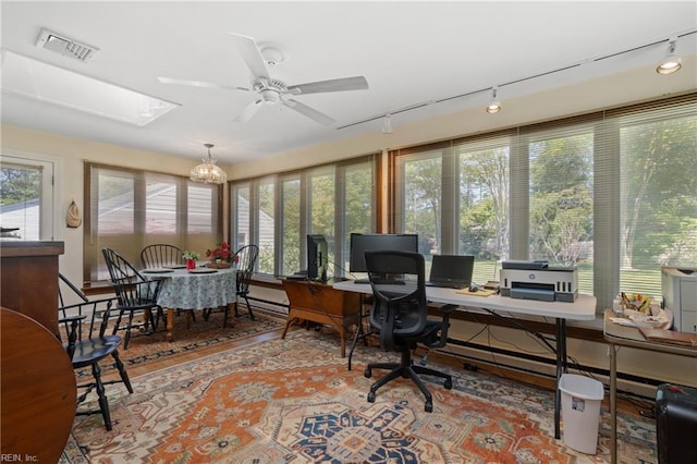 home office with a skylight, ceiling fan with notable chandelier, and a baseboard radiator