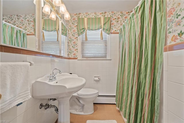 bathroom featuring baseboard heating, tile walls, toilet, and tile patterned flooring