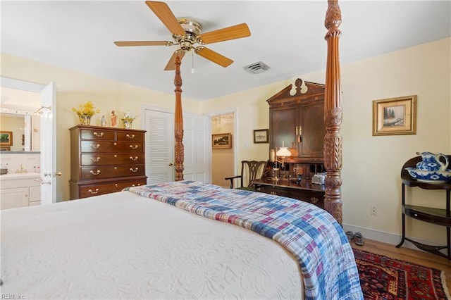 bedroom with ensuite bathroom, ceiling fan, sink, and hardwood / wood-style flooring