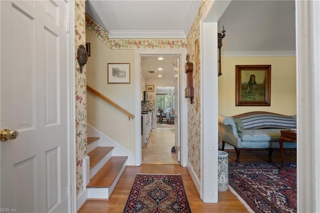 hallway with ornamental molding and light wood-type flooring