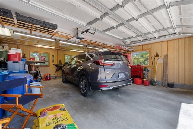 garage featuring a garage door opener and wood walls