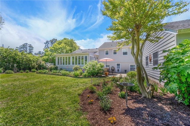 rear view of house with a lawn, a patio, and a sunroom