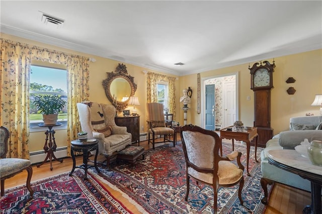 living area featuring crown molding, hardwood / wood-style floors, and a baseboard radiator