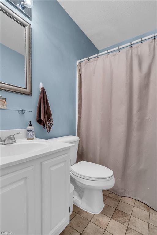 bathroom featuring toilet, tile patterned floors, and vanity