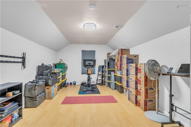 workout area featuring vaulted ceiling and wood-type flooring