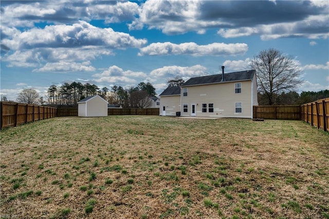 rear view of house with a storage shed and a lawn