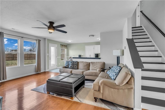 living room featuring ceiling fan and light hardwood / wood-style flooring