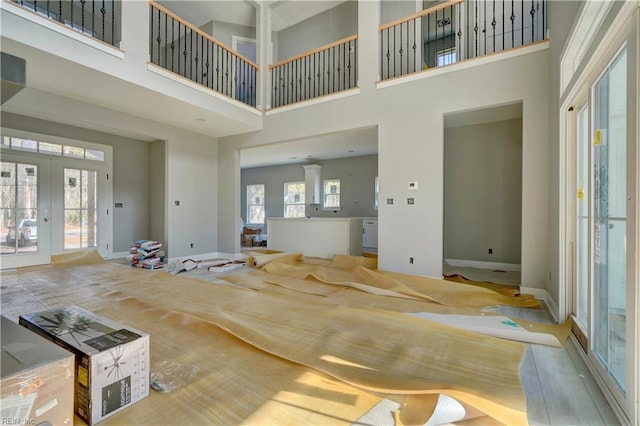 unfurnished living room with french doors, a high ceiling, and hardwood / wood-style flooring