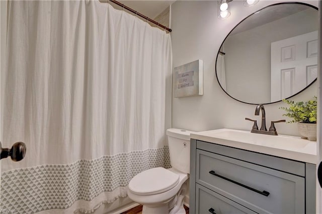 bathroom featuring curtained shower, toilet, and vanity