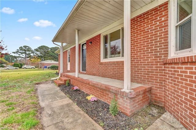 view of home's exterior with covered porch and a yard