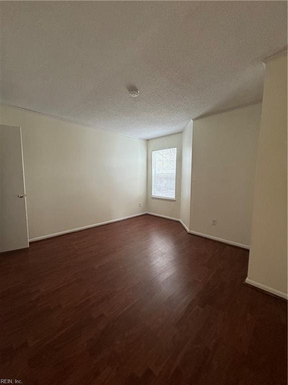 unfurnished room with a textured ceiling and dark hardwood / wood-style floors