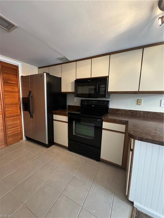 kitchen with black appliances and light tile patterned flooring