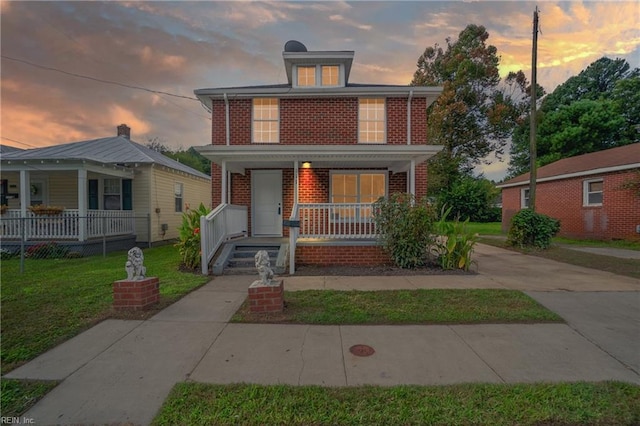 view of front of house with covered porch and a yard