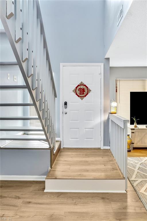 foyer entrance with a towering ceiling and hardwood / wood-style floors