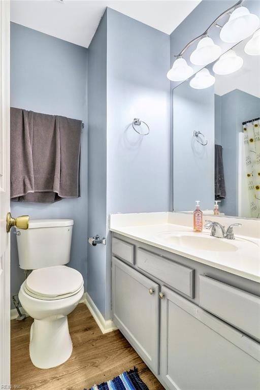 bathroom featuring vanity, wood-type flooring, and toilet