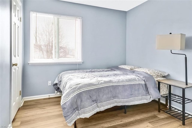 bedroom featuring multiple windows and light wood-type flooring