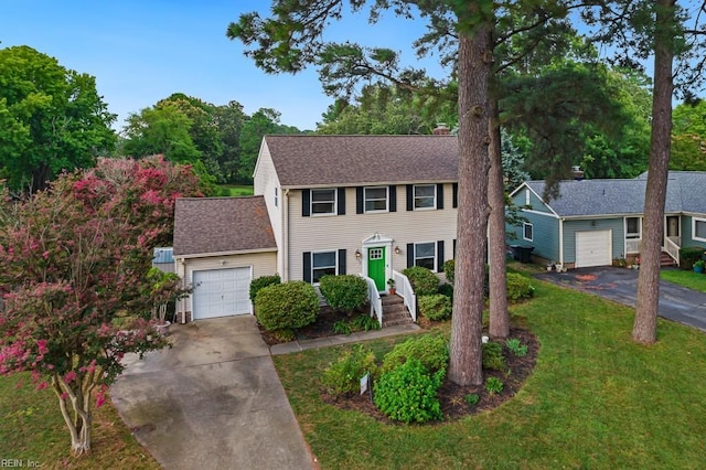 colonial inspired home with a garage and a front lawn