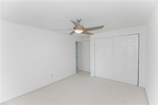 unfurnished bedroom with ceiling fan, a closet, and light carpet