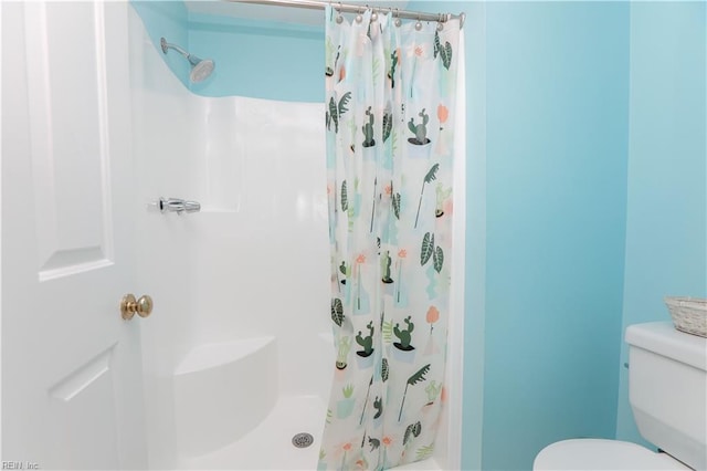 bathroom featuring toilet and a shower with curtain