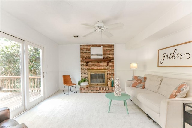 carpeted living room featuring ceiling fan and a fireplace