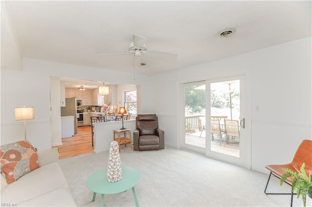 carpeted living room with ceiling fan