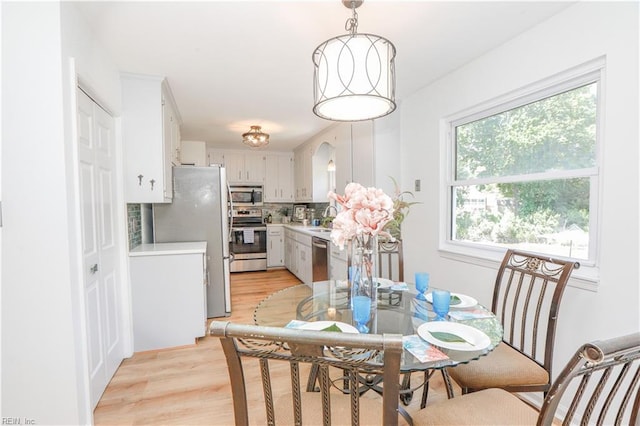 dining space with sink, a wealth of natural light, and light hardwood / wood-style floors