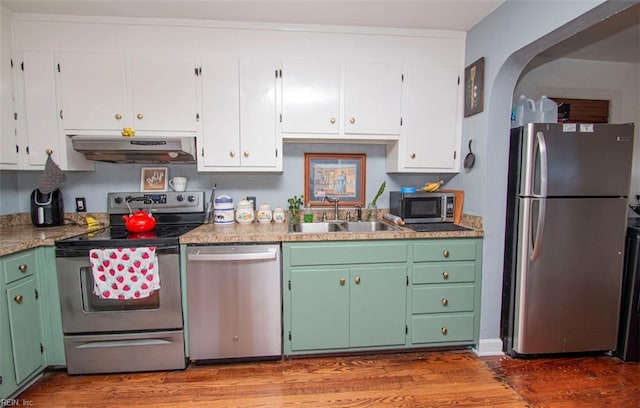 kitchen with white cabinetry, stainless steel appliances, light stone countertops, light hardwood / wood-style flooring, and sink