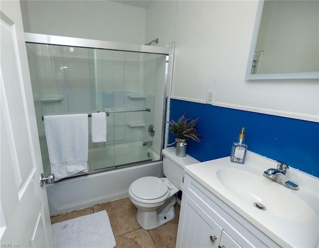 full bathroom featuring toilet, combined bath / shower with glass door, tile patterned flooring, and vanity