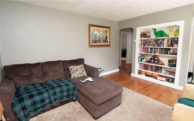 living room with a textured ceiling and wood-type flooring