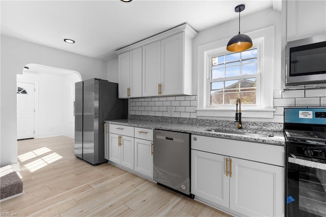 kitchen featuring appliances with stainless steel finishes, decorative backsplash, white cabinetry, and sink