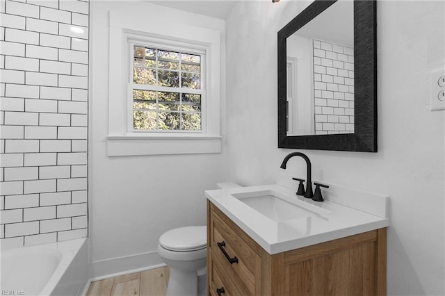 full bathroom with toilet, tiled shower / bath combo, hardwood / wood-style floors, and vanity