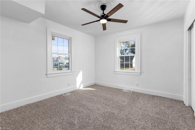 carpeted empty room with ceiling fan and a healthy amount of sunlight