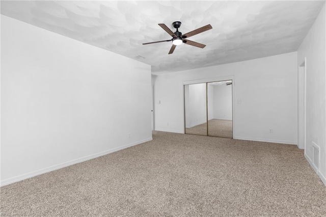 unfurnished bedroom with ceiling fan, a closet, and carpet flooring