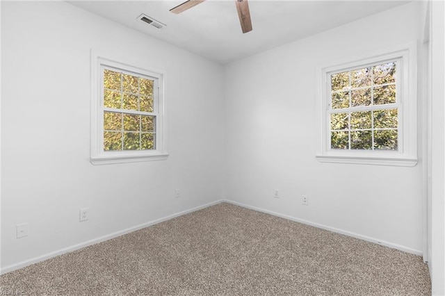 carpeted spare room with ceiling fan and a healthy amount of sunlight