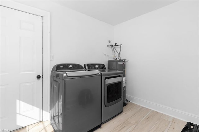 clothes washing area featuring electric water heater and washer and dryer